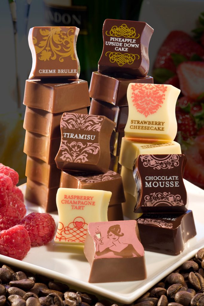 Stack of gourmet chocolates with raspberries and coffee beans